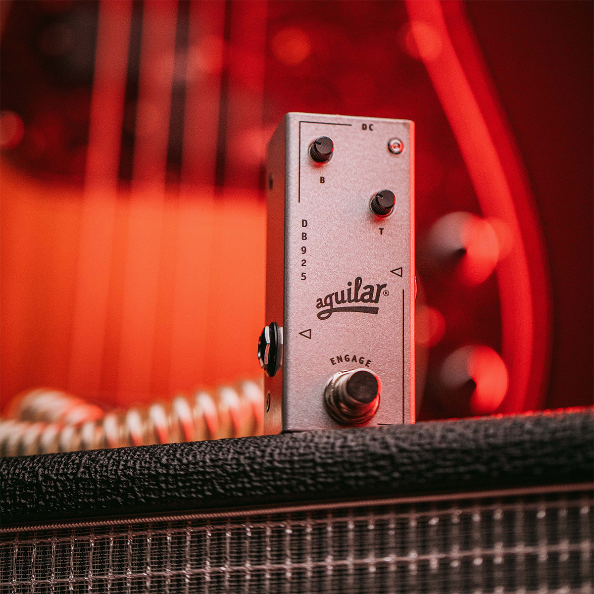 Aguilar DB 925 bass preamp pedal standing on top of Aguilar cabinet.